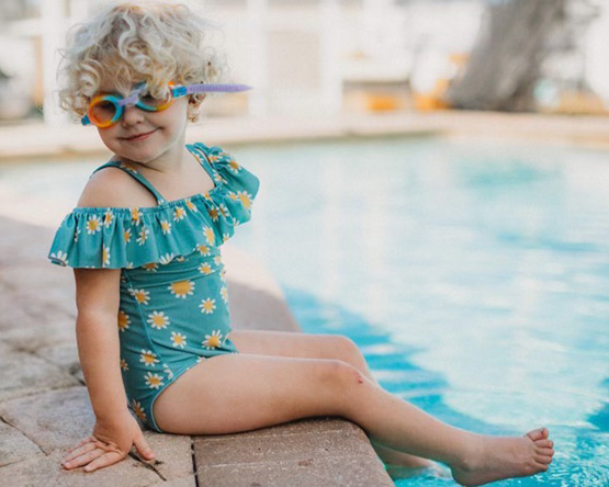 Child sitting on the edge of a pool